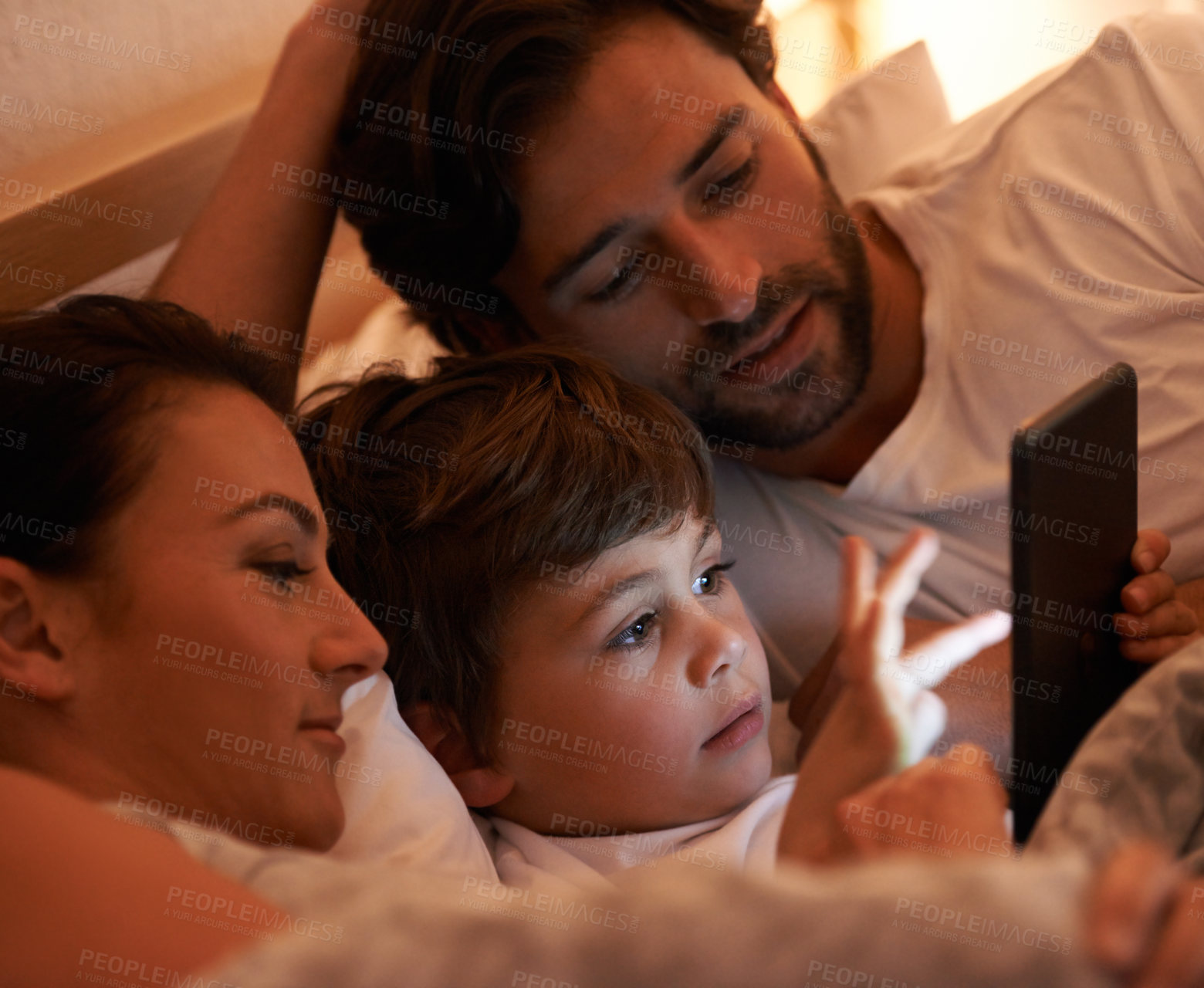 Buy stock photo Parents, boy and tablet in bedroom at night for app, bonding and watch movies together in family house. Dad, mom and child in bed with touchscreen, cartoon or film with streaming subscription in home