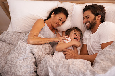 Buy stock photo Parents, boy and tickling with laughing in bed for care, bonding or love with joke in family house. Father, mother and child with funny game, excited or happy for comic smile together in home bedroom