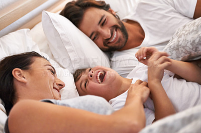 Buy stock photo Cropped shot of a young family in bed together