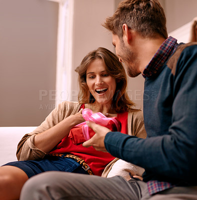 Buy stock photo Couple, surprise and present in lounge of home, happiness and together for anniversary in house. Man, smile and giving gift to girlfriend with love in living room of house, woman and shock with wow