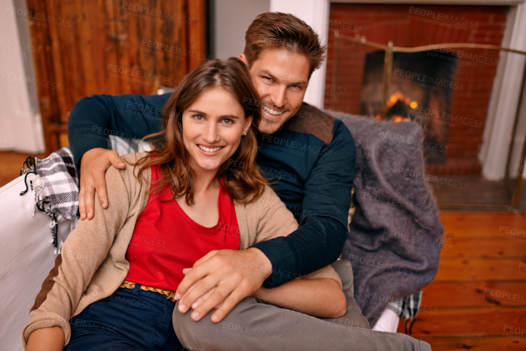 Buy stock photo Couple, portrait and together in living room for romance, partners and smile for relationship. People, happy and love for marriage in house with fireplace to keep warm in winter, sitting and hugging