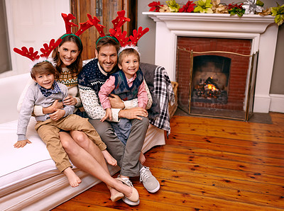Buy stock photo Christmas, portrait and happy family on sofa in home for holiday or festive celebration. Xmas, parents and smile of children in living room with antlers, bonding and kids together at party in house