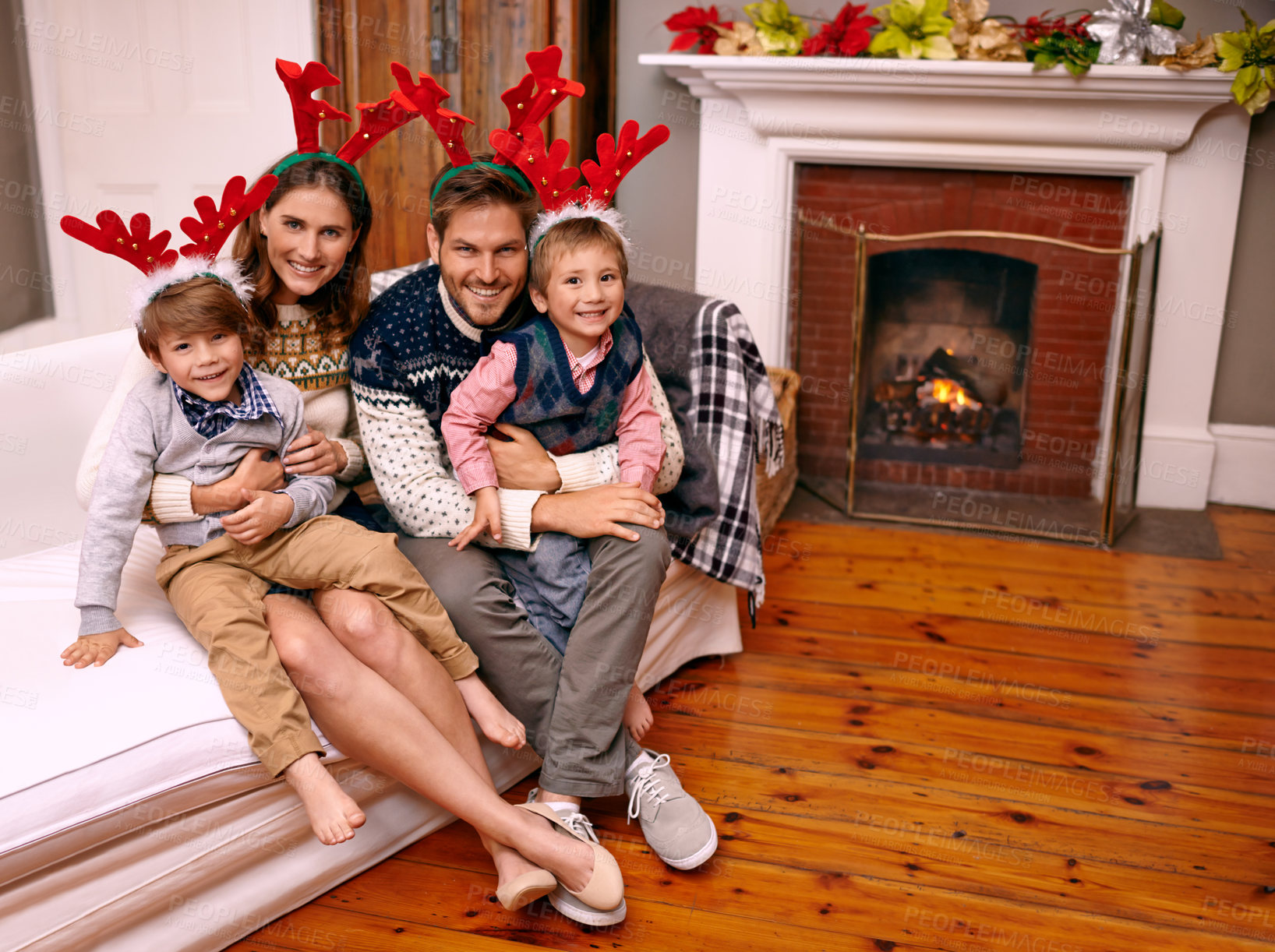 Buy stock photo Christmas, portrait and happy family on sofa in home for holiday or festive celebration. Xmas, parents and smile of children in living room with antlers, bonding and kids together at party in house