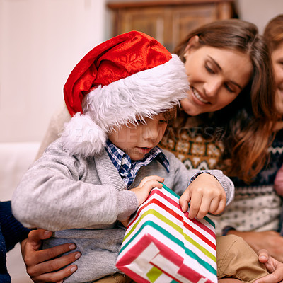 Buy stock photo Christmas, happy family and kid with gift box in living room with smile, gratitude and bonding together in home. Mother, father and son with present, love and festive holiday celebration on sofa.