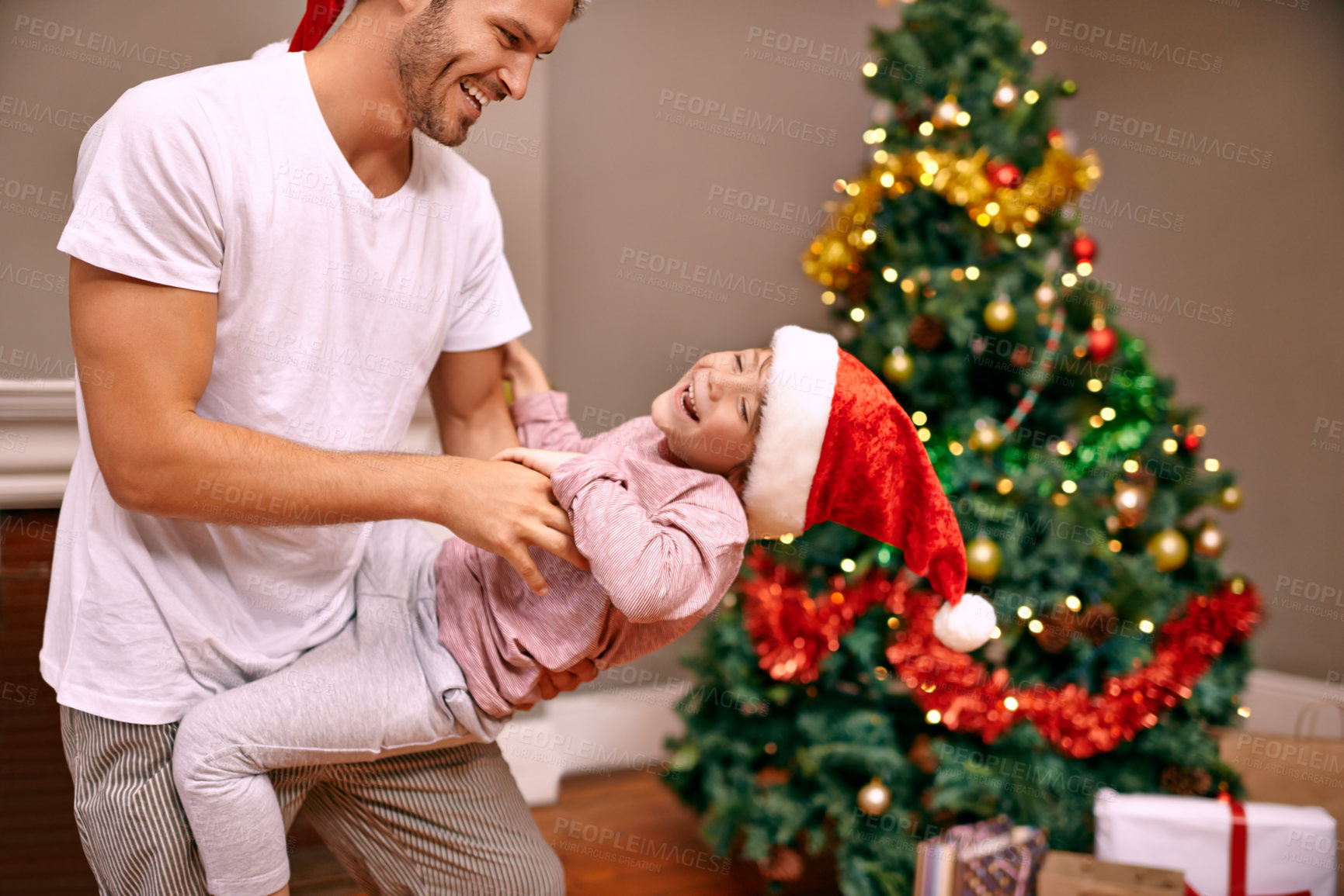 Buy stock photo Father, son and laughing with bonding on christmas for celebration, play and love in the morning with santa hats. Family, man and child with smile, relax and enjoying holiday season in lounge of home