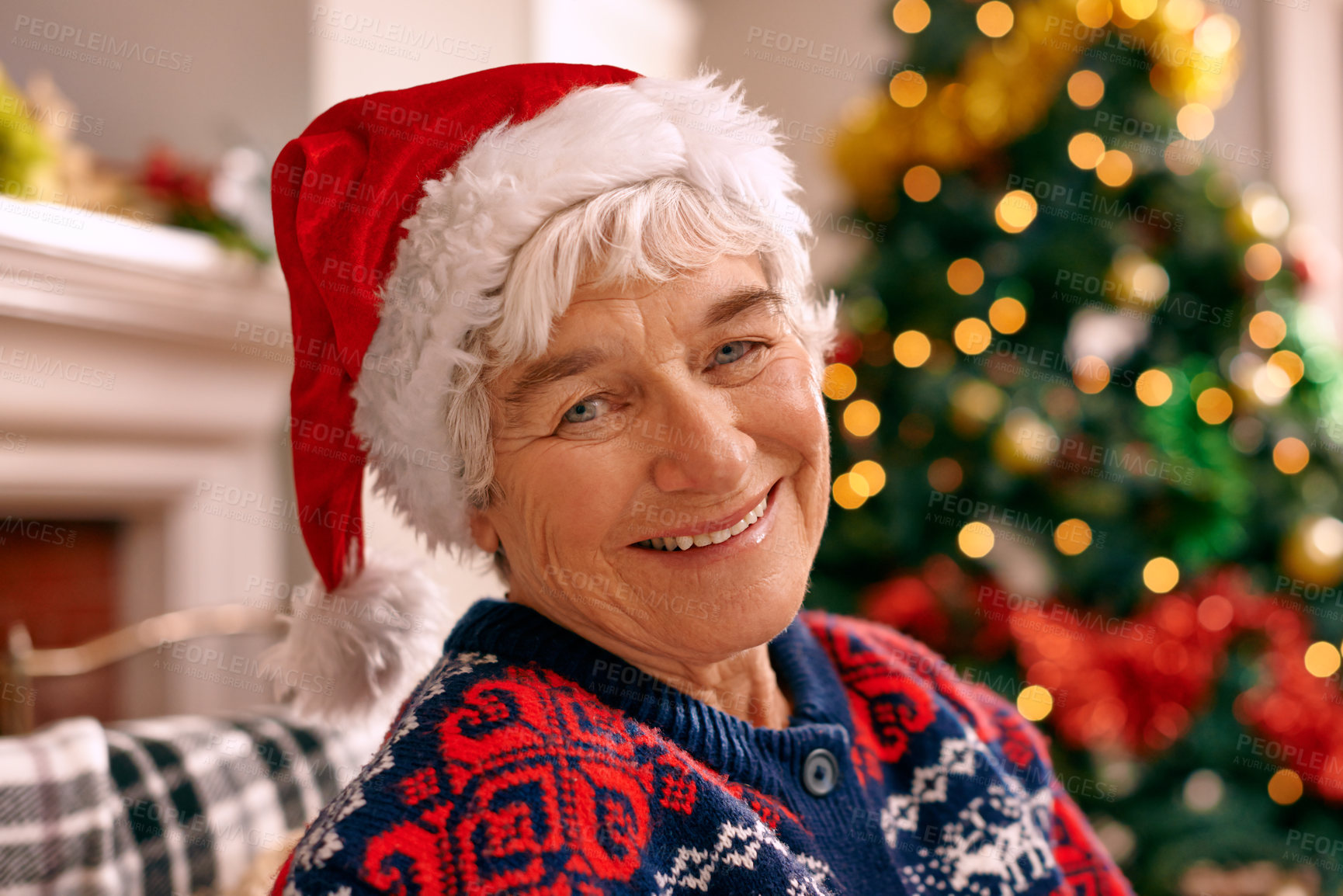 Buy stock photo A senior woman sitting inside wearing a Christmas hat