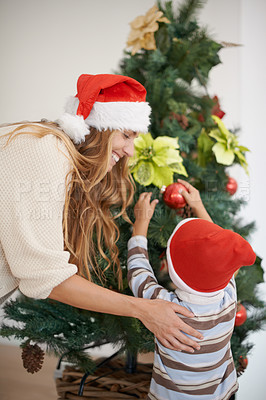 Buy stock photo Mom, child and tree decoration for Christmas for bonding, fun and family in home. Festive, xmas decor and mother with kid, ornament and happy holiday together with support, love and celebration.