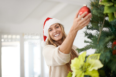 Buy stock photo Woman, portrait and tree decoration for Christmas with smile, fun and excited in home. Festive, xmas decor and girl with ornament, Santa hat and happy December holiday event in apartment living room.