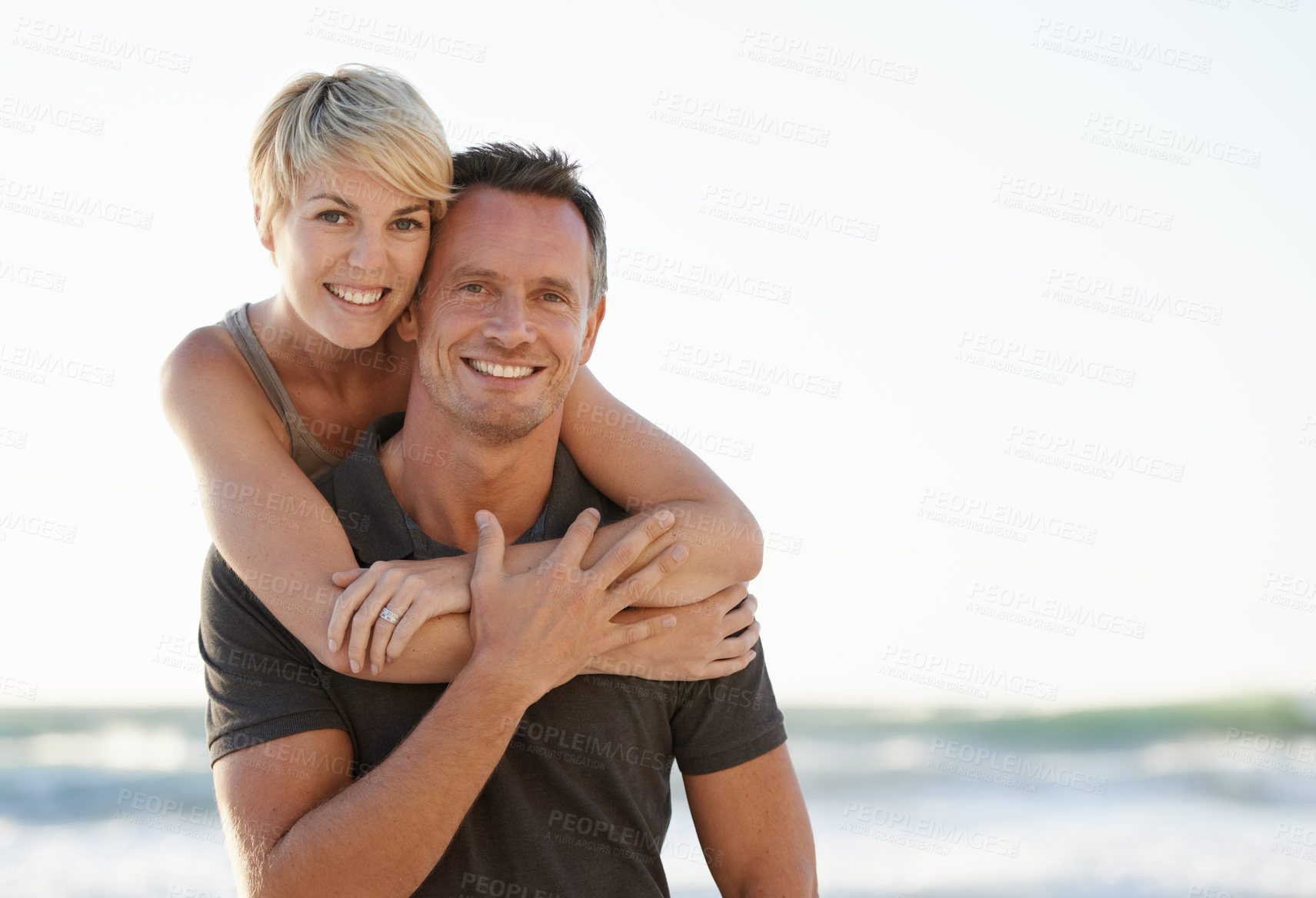 Buy stock photo Couple, portrait and happy on beach with hug for bonding, honeymoon date and weekend holiday. Face, man and woman with embrace, smile and love in water by sea for vacation, travel and adventure