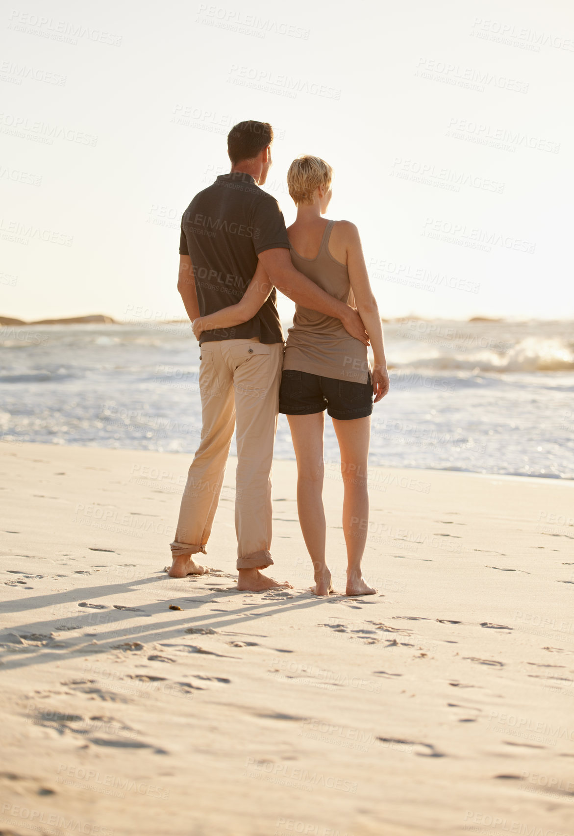 Buy stock photo Travel, beach and back of couple at sunset for bonding, romantic adventure and relationship by ocean. Dating, love and man and woman hug, embrace and relax on holiday, vacation and weekend in nature