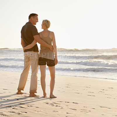 Buy stock photo Love, beach and back of couple at sunset for bonding, relax together and relationship by ocean. Dating, travel and man and woman hug, embrace and smile on holiday, vacation and weekend in nature