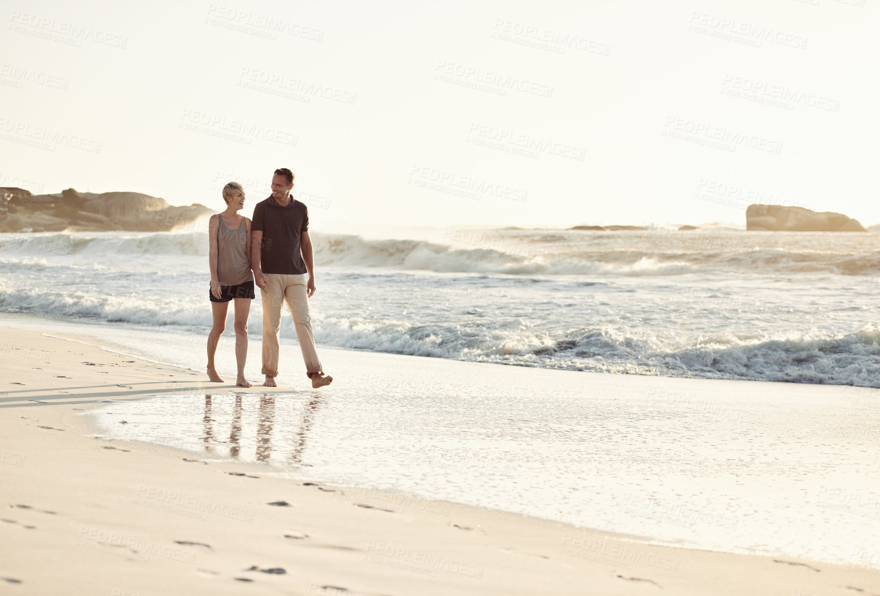 Buy stock photo Couple, talking and beach at sunset for romantic date, weekend getaway or vacation in Indonesia. Happy woman, man or people in love with smile for evening walk, bonding and relaxation by shore