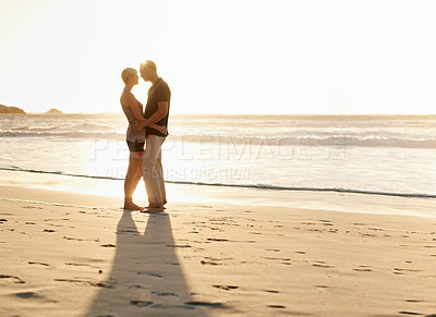Buy stock photo Couple, kiss and beach at sunset for romantic date, weekend getaway and vacation in Mexico. Woman, man or people in love with hug for evening walk, bonding and together in caring happy relationship