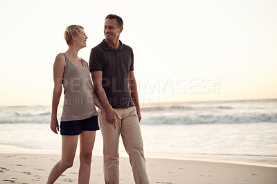 Buy stock photo Couple, beach and walking evening on holiday for marriage connection in paradise or honeymoon, sunshine or together. Man, woman and smile at sunset in California for stress relief, explore or break