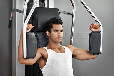Buy stock photo Fitness, resistance exercise and man in gym for arm muscle training for health, wellness and strength. Active, body and young male athlete on machine with weights for bodybuilding in sports center.