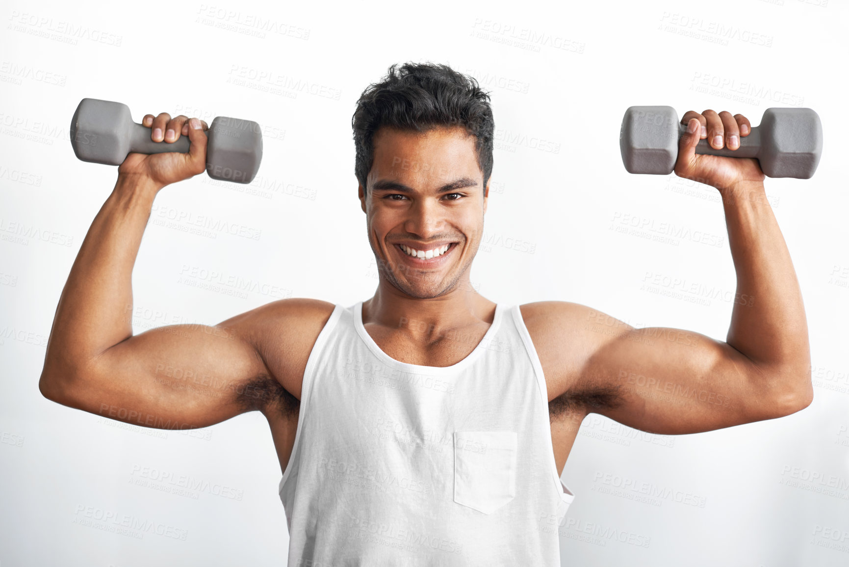 Buy stock photo Studio portrait of an athletic young man holding up dumbbells