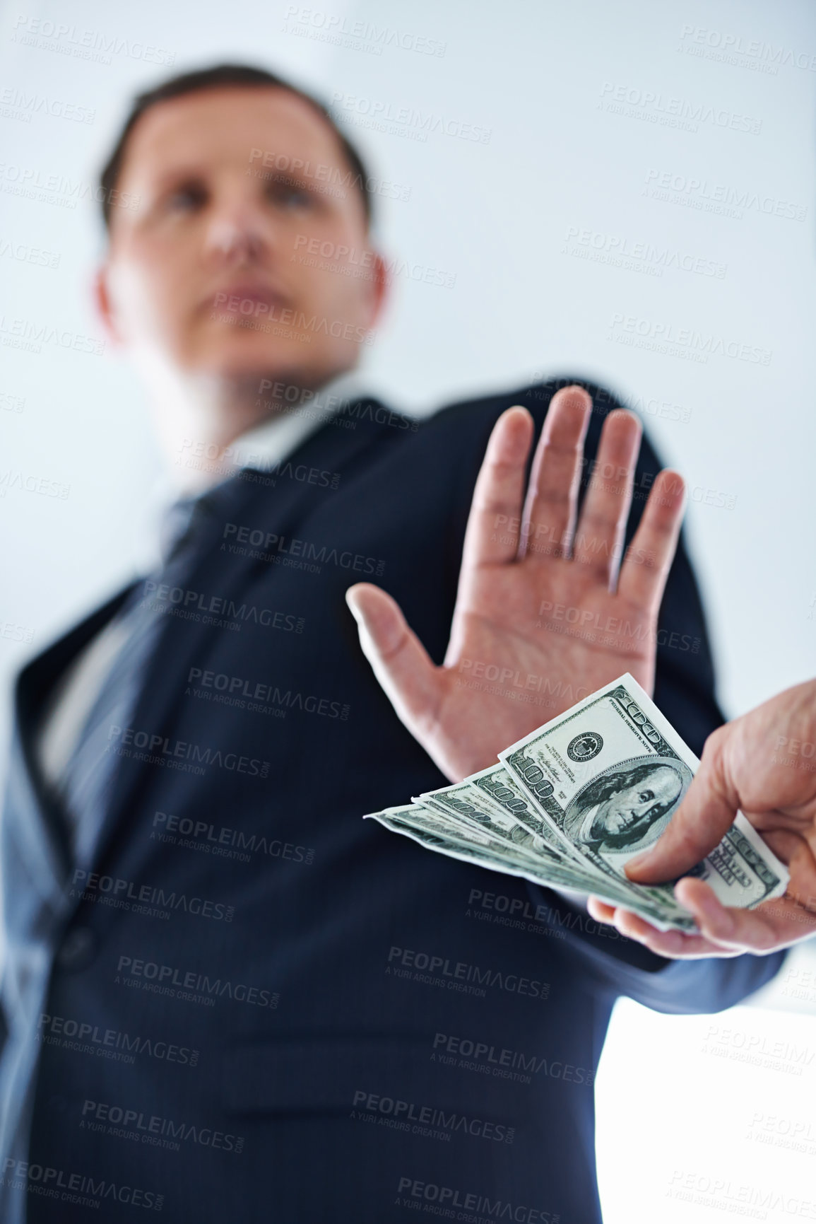 Buy stock photo Low-angle view of a businessman refusing a bribe