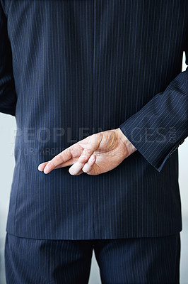 Buy stock photo Businessman, back and fingers crossed with luck for hope, confidential or secret on a studio background. Closeup or rear view of man or business employee hiding hand in conspiracy, lie or corruption