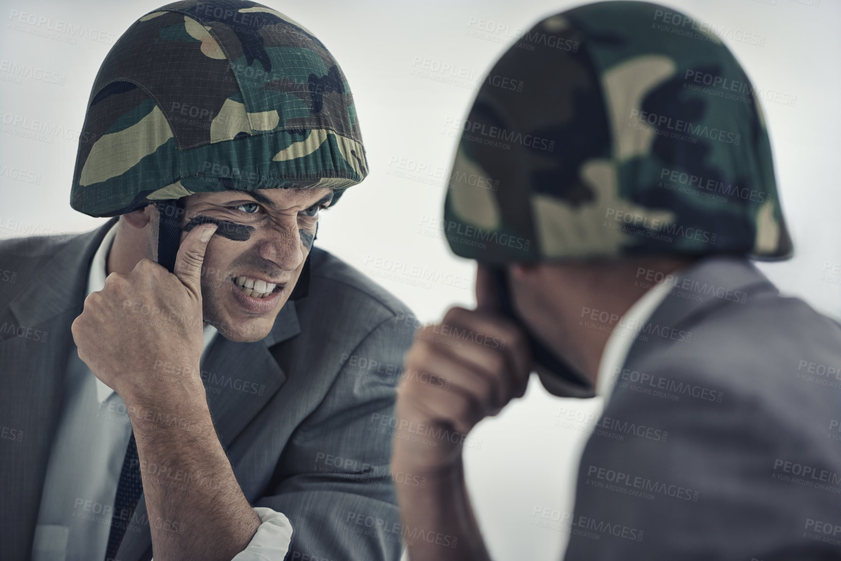 Buy stock photo A young man applying camouflage paint to his face