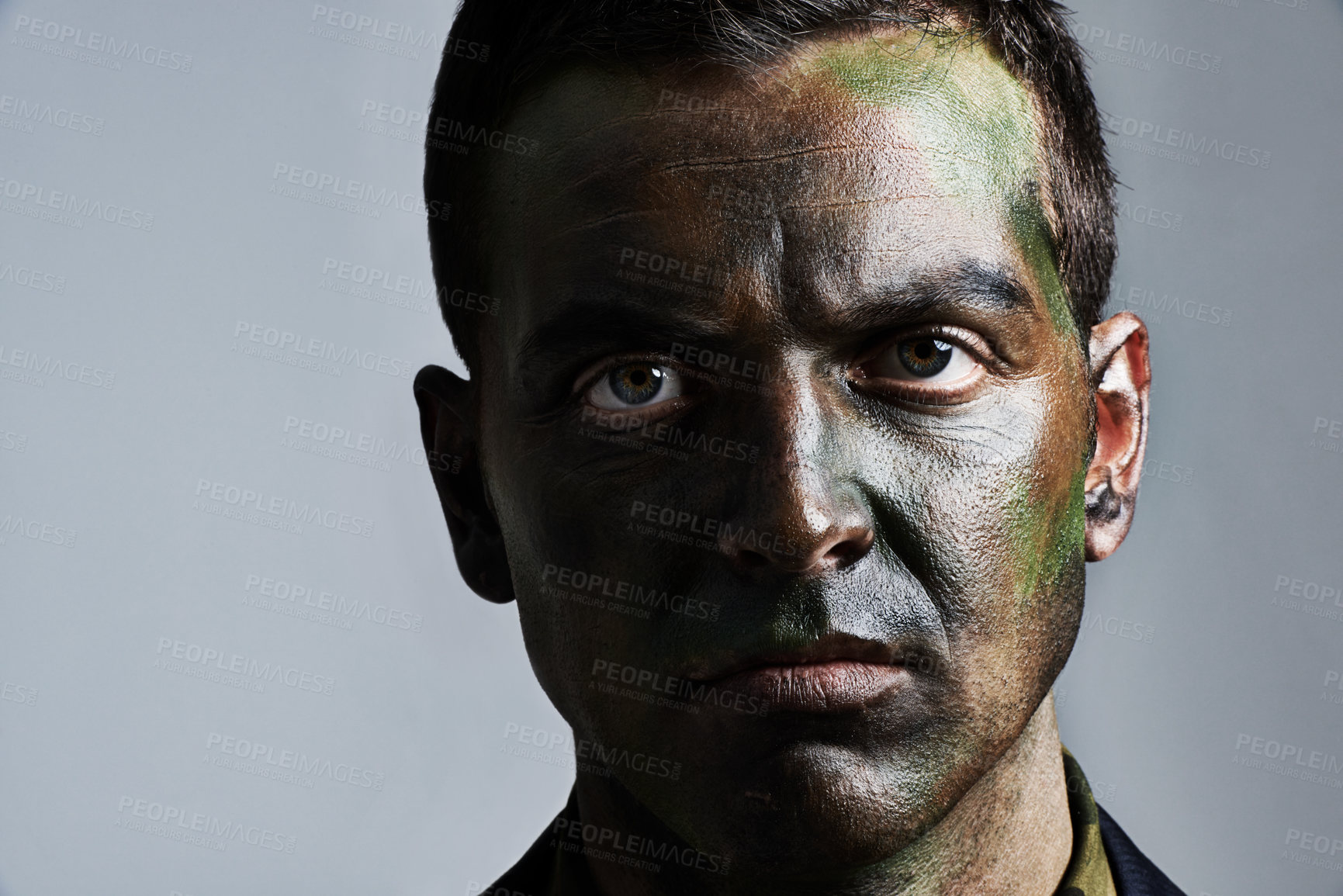 Buy stock photo Man, portrait and camouflage with face paint for war, battle or military service on a gray studio background. Closeup of male person, army or solider with color dye for undercover disguise on mockup
