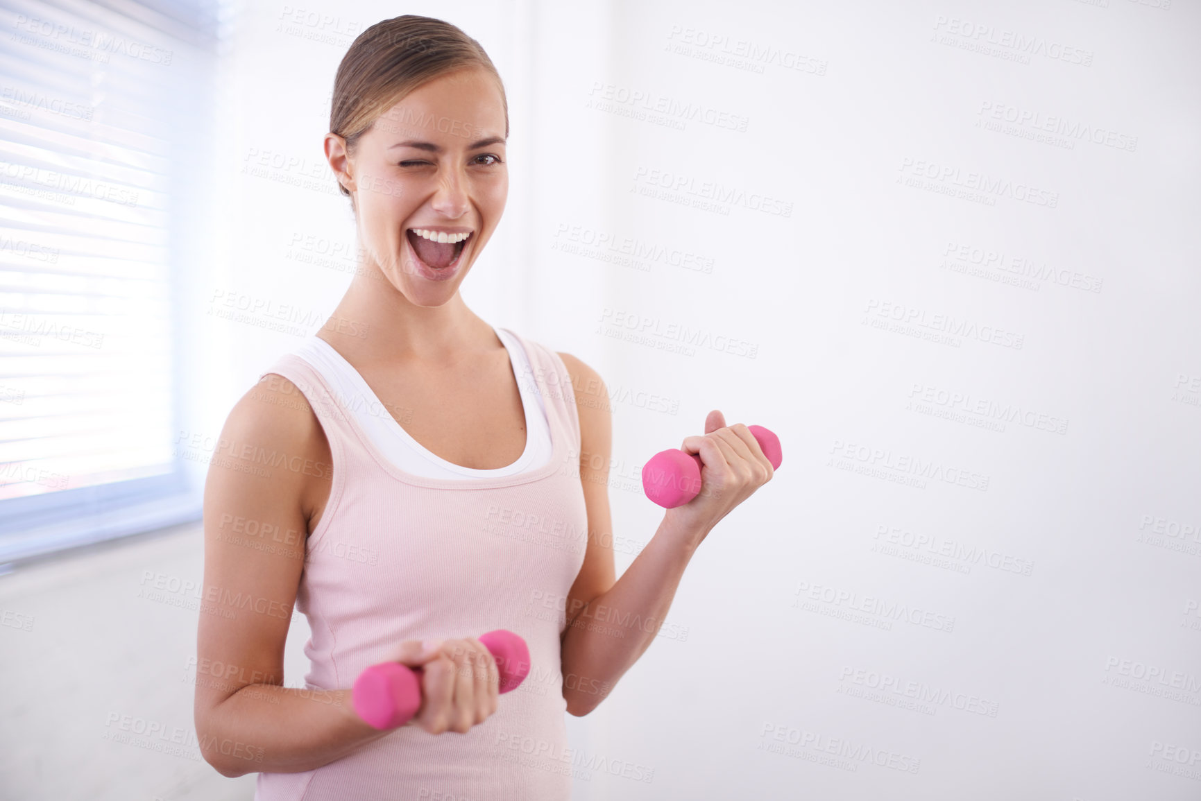 Buy stock photo An attractive young woman working out with weights and winking