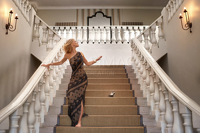 Buy stock photo A young woman losing a shoe while running down a magnificent staircase