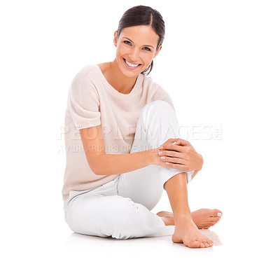 Buy stock photo Studio shot of a young woman sitting on the floor and hugging her knee
