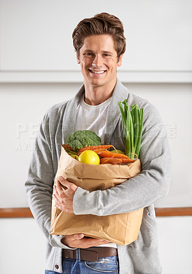 Buy stock photo Portrait, vegetables and man with brown paper bag, smile and home with nutrition and vegetarian. Face, person and guy with groceries and healthy ingredients with products, food and diet with wellness