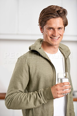 Buy stock photo Smile, portrait and man with glass of water in kitchen of home for hydration, health and wellness. Happy, confident and young male person drinking fresh h2o liquid or beverage in modern apartment.