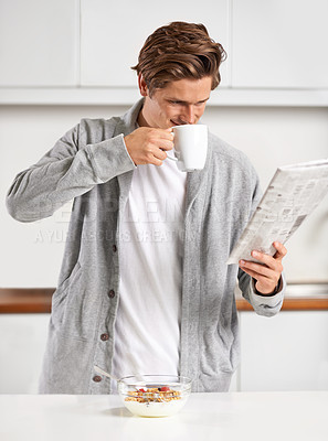 Buy stock photo Coffee, breakfast and man with newspaper in kitchen for information at modern apartment. Nutrition, cereal and young male person drinking cappuccino or latte and reading journalism article at home.