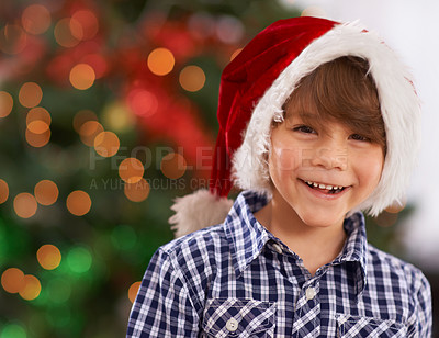 Buy stock photo Christmas, portrait and happy child in home with bokeh for festive celebration, party and holiday. Face, smile and boy in hat for xmas, laughing or excited facial expression in house in Australia
