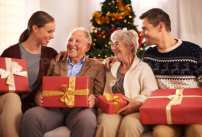Buy stock photo People, grandparents and family with Christmas gift for festive season together for celebration, presents or holiday. Elderly man, woman and couch at home in Canada for bonding, vacation or relaxing