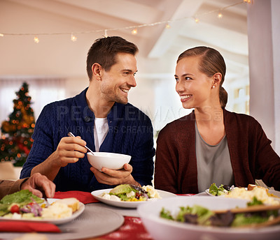 Buy stock photo Christmas, happy couple and eating dinner in house, smile or bonding together at party. Xmas, man or woman at table for food at festive celebration, relax or hungry with salad for meal in home