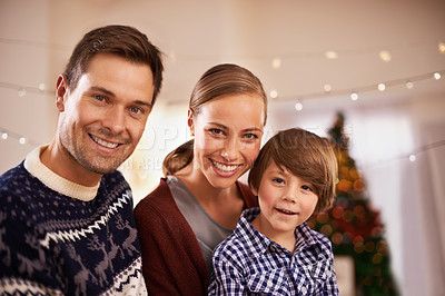 Buy stock photo Christmas, family and happy child with parents in home for love, connection and bonding at festive celebration with smile. Xmas, face and kid, mother and father together on holiday at party on bokeh