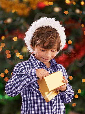 Buy stock photo Happy, Christmas and boy child with present for celebration or surprise at festive party at home. Smile, santa hat and cute young kid opening a gift box for xmas event at modern house with decoration