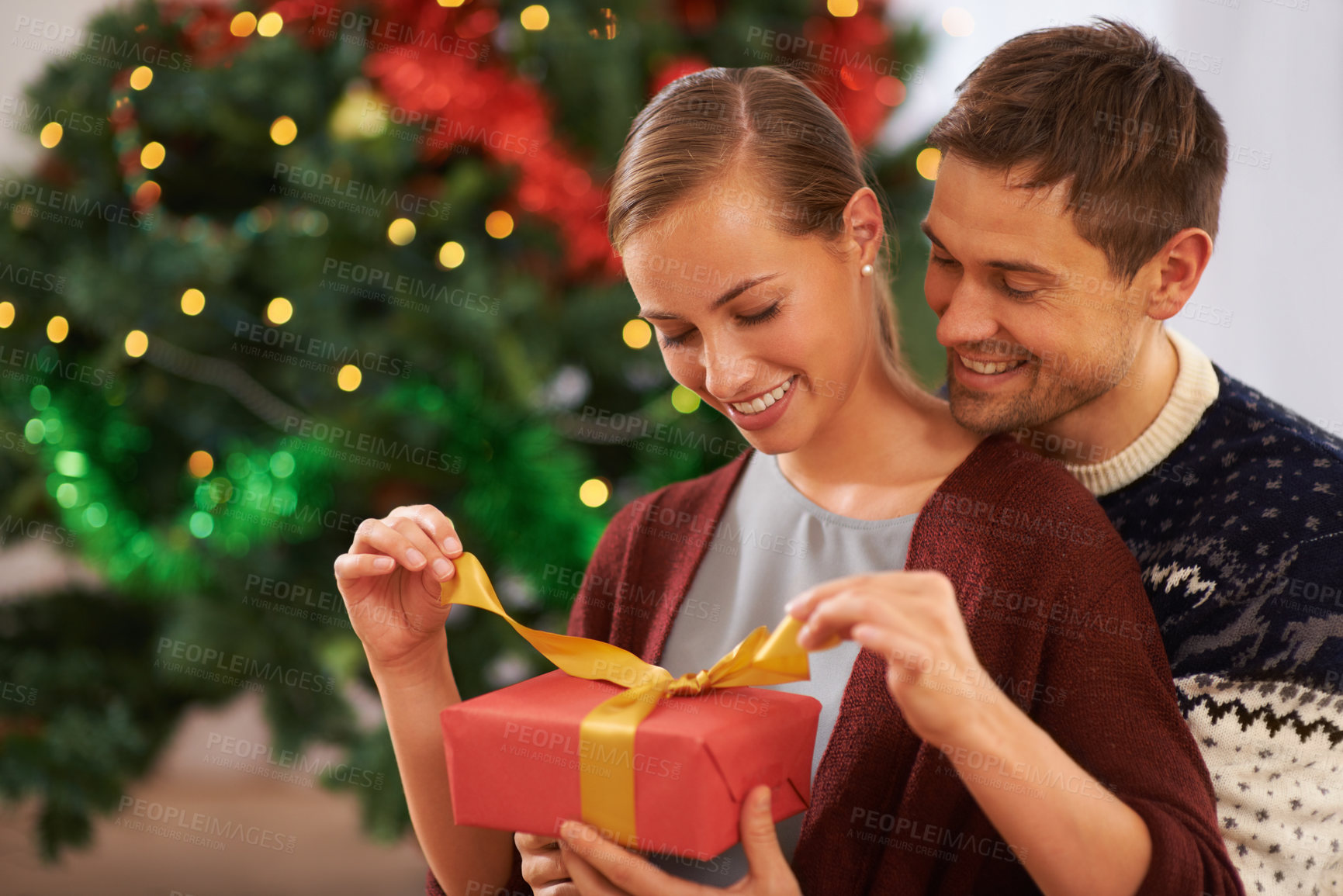 Buy stock photo Smile, Christmas gift and couple in living room at home for festive celebration together. Happy, love and young man and woman with holiday present box for xmas event or party at modern house.