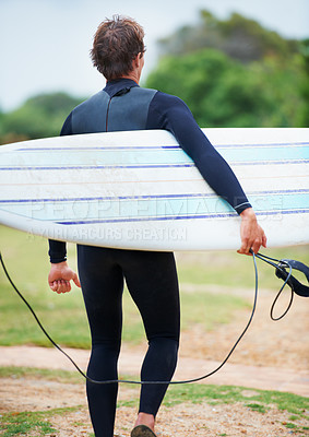 Buy stock photo A surfer carrying his board on his way to the beach