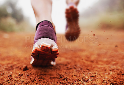 Buy stock photo Closeup shot of a woman running on a trail on a misty morning