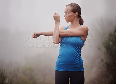 Buy stock photo Fitness, woman and stretching arms outdoor, wellness or sports with fog. Park, serious and young person warm up in nature with mist for exercise, training and thinking of workout for body health