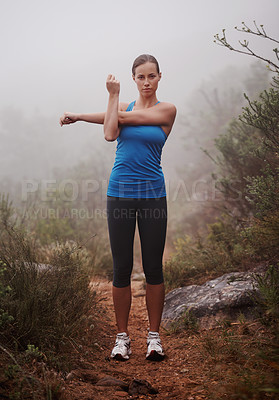 Buy stock photo Portrait, fitness and woman stretching in nature for wellness, sports and body health with fog. Runner, serious person and warm up arms outdoor with mist for exercise, training or workout at park