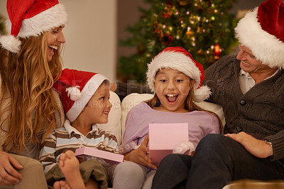 Buy stock photo Parents, living room and christmas with gift, surprise and joy with home on sofa. Family, children and celebration with present, gratitude and thank you with happiness or appreciation for holiday