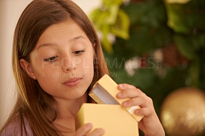 Buy stock photo A young girl opening a Christmas gift