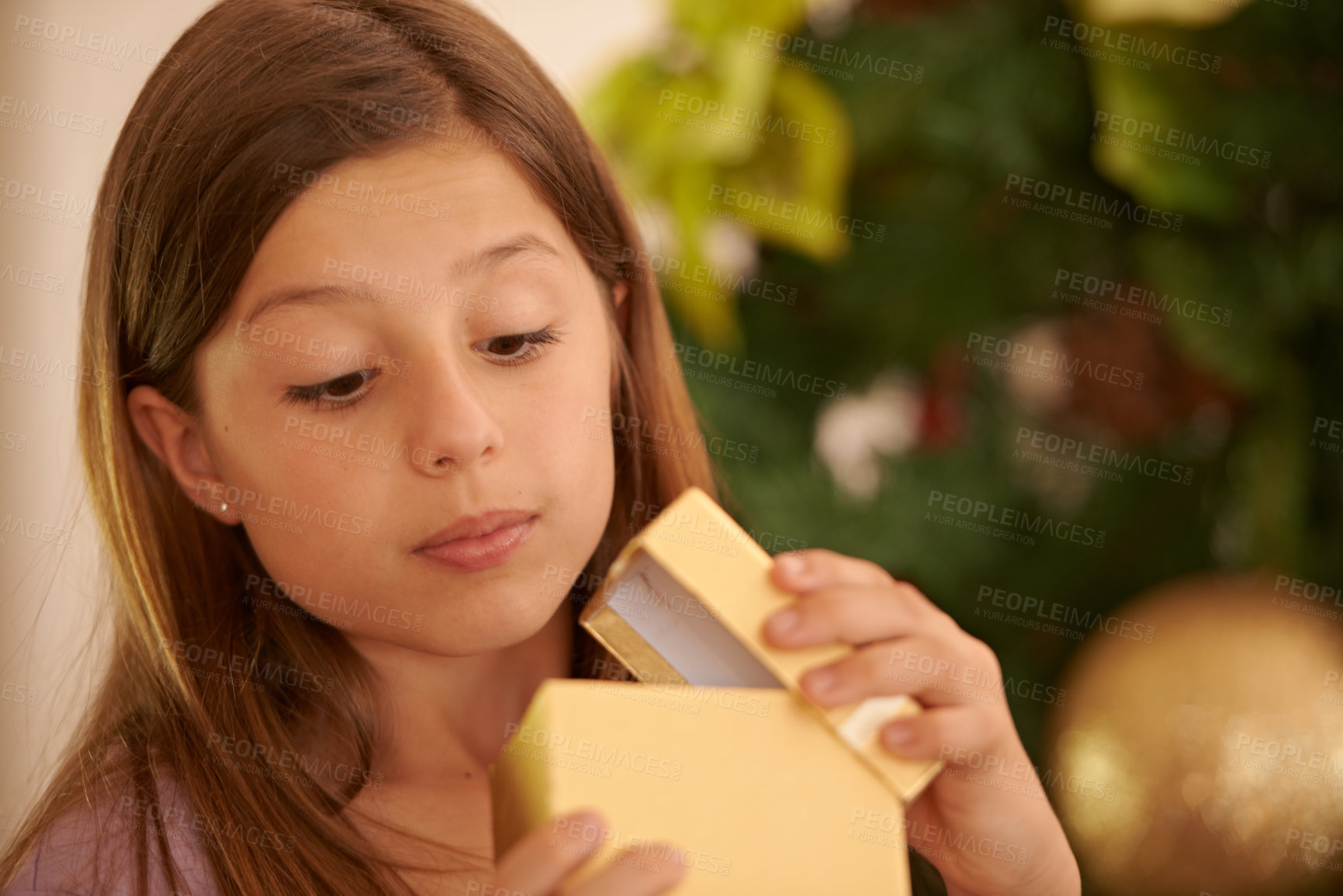 Buy stock photo A young girl opening a Christmas gift