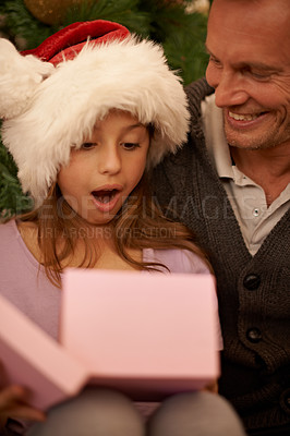 Buy stock photo Christmas, surprise and child with gift box, dad and celebration together with happy family. Holiday, father and daughter smile in living room for present giving, festive xmas and love in home.