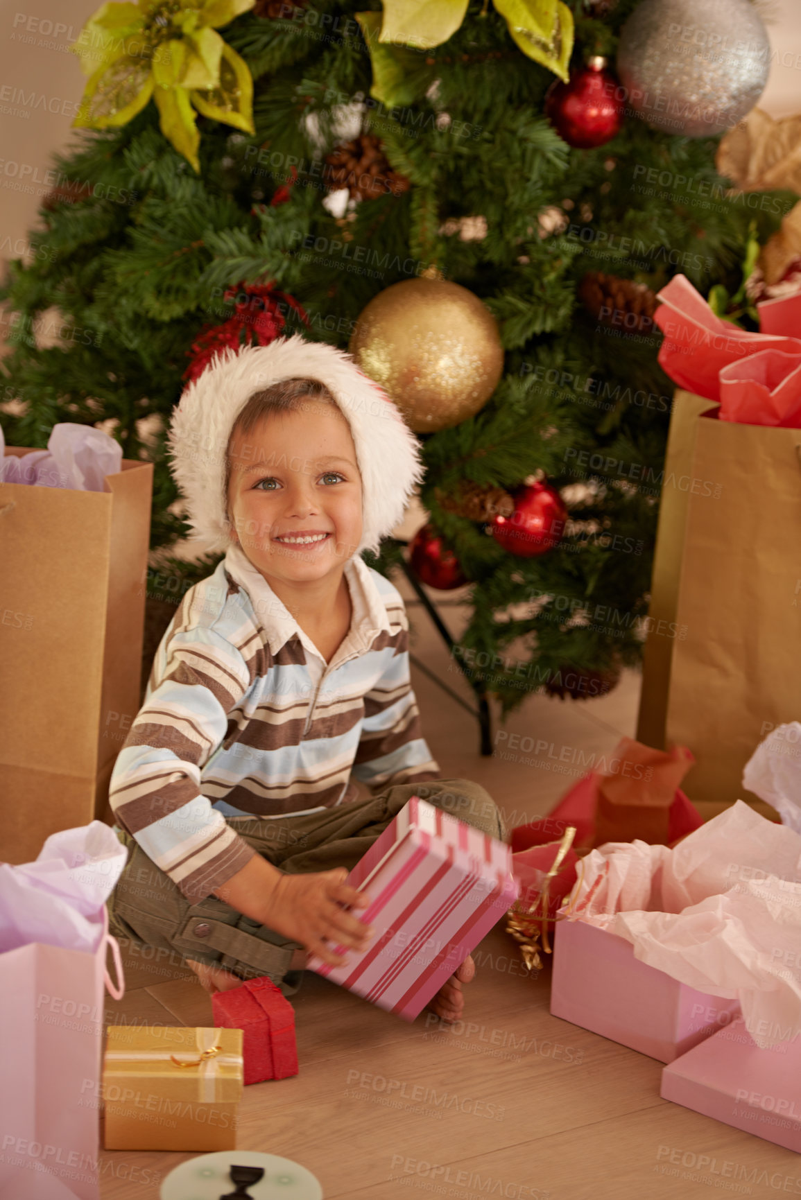 Buy stock photo Boy, child and face with gift on christmas on floor in living room of home with happiness or santa hat. Kid, person and smile with present for celebration, tradition or holiday in lounge of apartment
