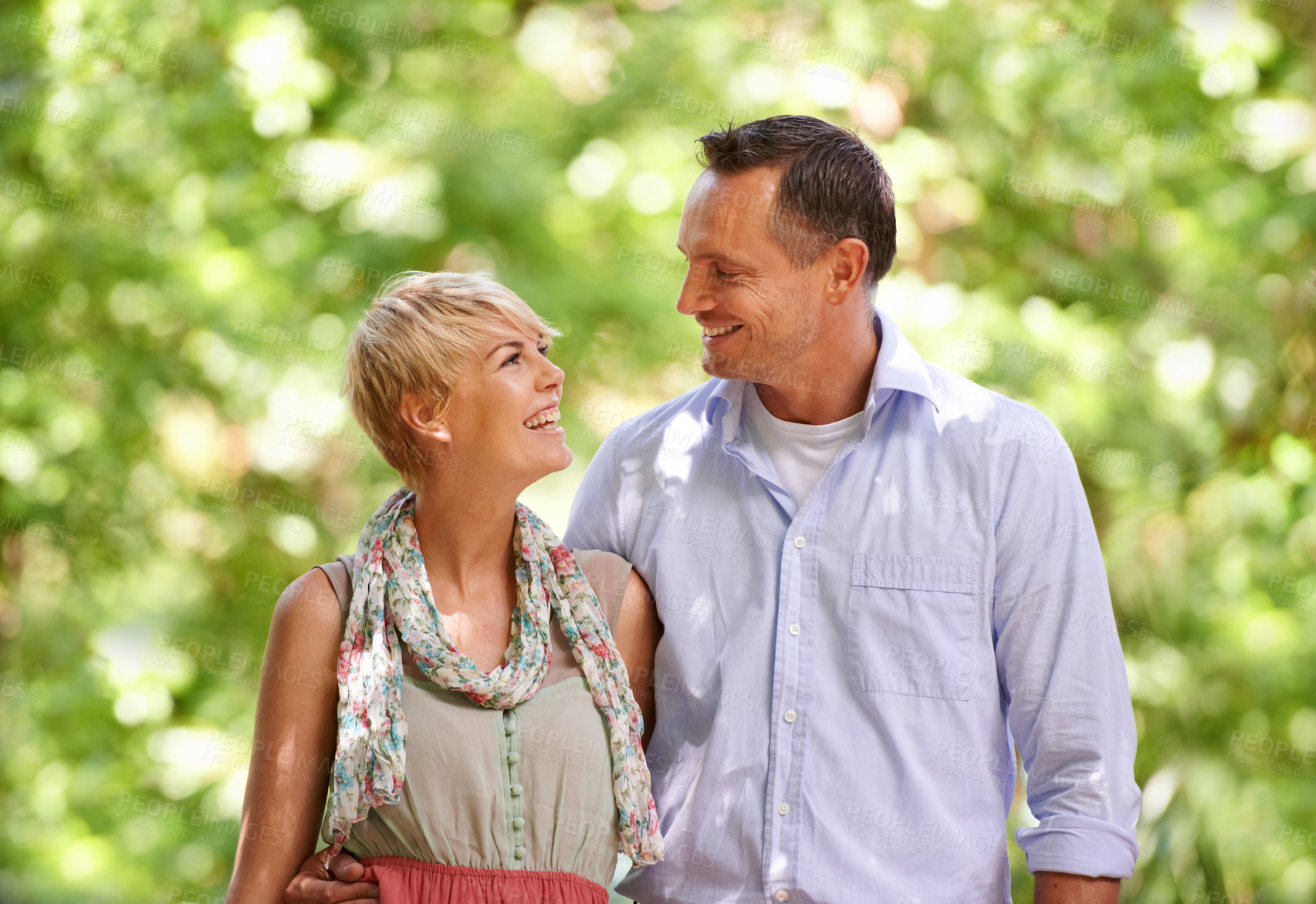 Buy stock photo Hug, love and happy couple in a park for travel, adventure and bonding in nature together. Smile, romance and people embrace in a forest for summer date, reunion or weekend, holiday or fun vacation