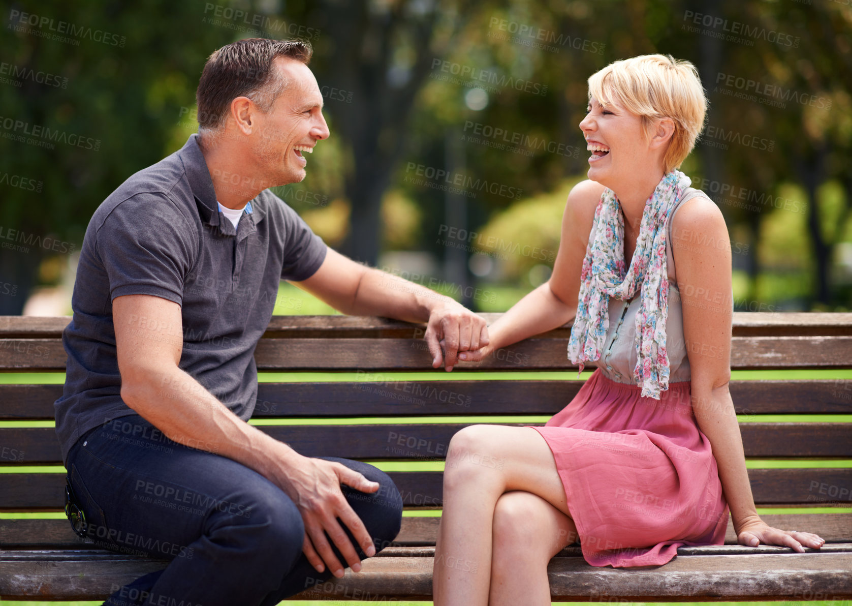 Buy stock photo Love, laughing and happy couple on a park bench with funny conversation, gossip or bonding outdoors together. Trust, communication or people sharing comic, chat or speaking on travel, trip or holiday