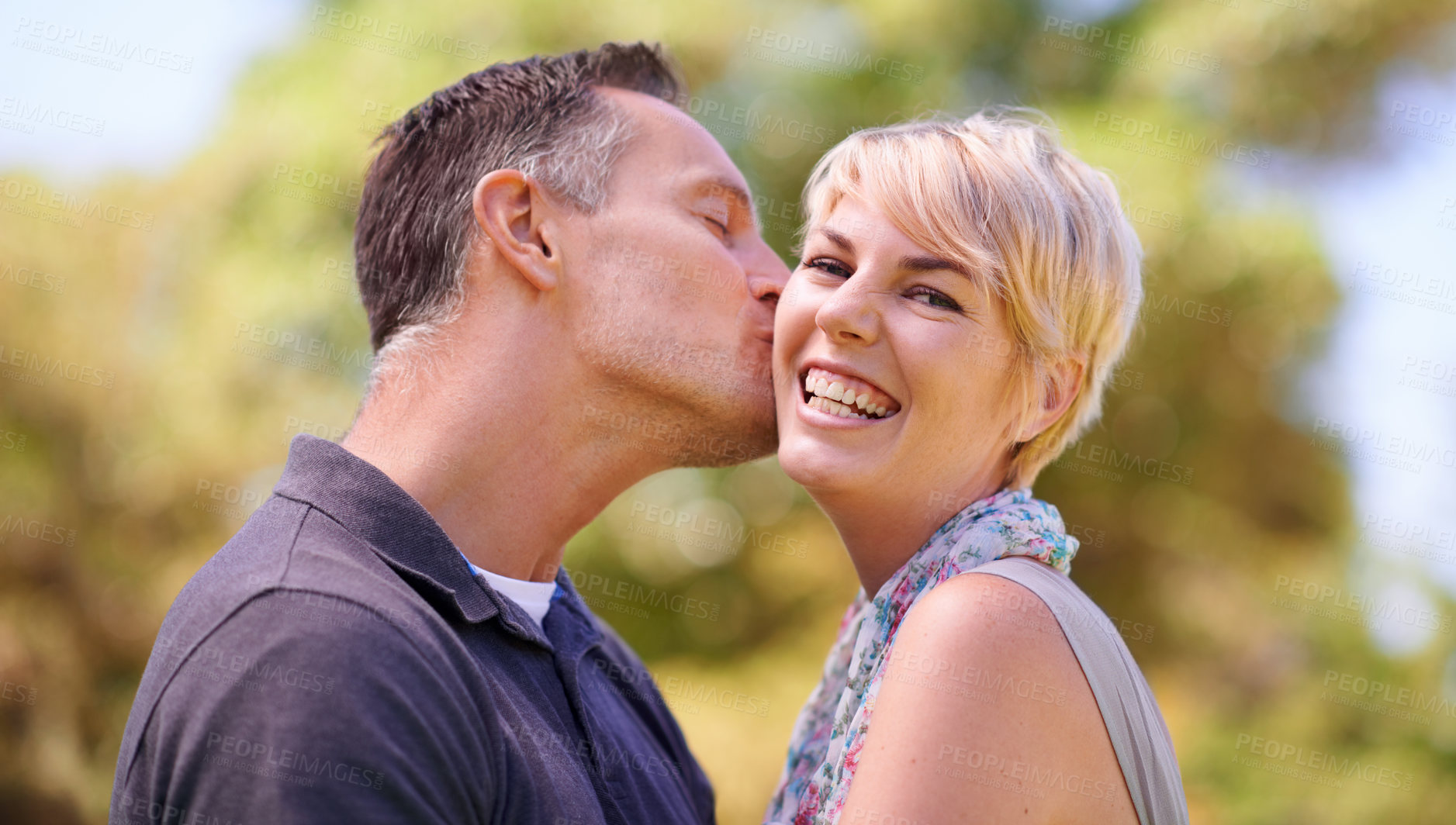 Buy stock photo Portrait, couple and love with kiss in happiness on outdoor, affection and romance with date. Park, relationship and together with smile for bonding, care and trust with commitment for support