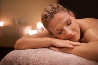 Buy stock photo Cropped shot of a woman in a day spa relaxing on a massage table