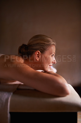 Buy stock photo Cropped shot of a woman in a day spa relaxing on a massage table